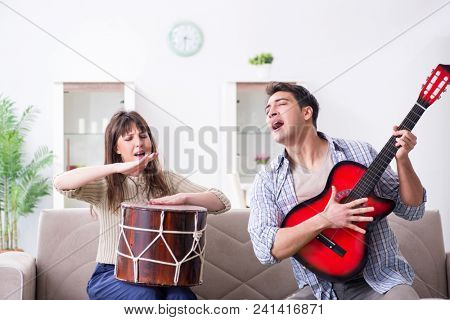 Young family singing and playing music at home