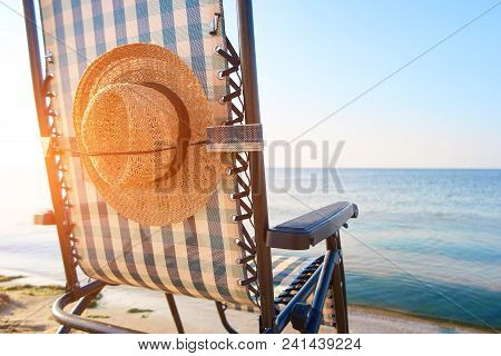 Beach Accessories, Woman's Hat Affixed To Deck Chair Back.