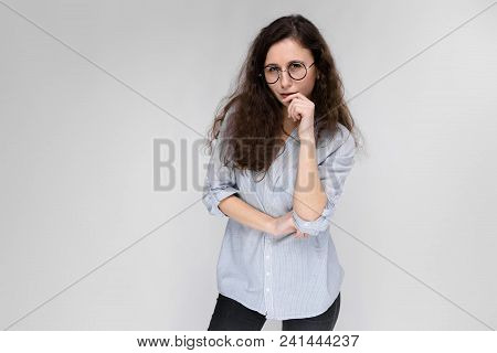 Young Girl With Glasses On A Gray Background. Portrait Of A Young Beautiful Girl. A Charming Girl In