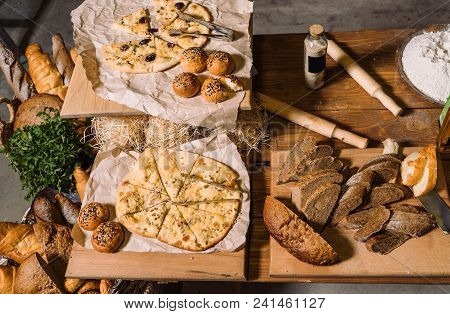 Assortment Of Different Kind Of Cereal Bakery: Bread, Pasties, Buns, Pretzel And Croissant On Old Wo
