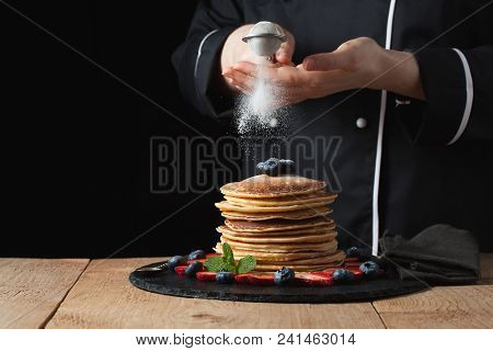 Serving Pancakes With Powdered Sugar And Berries. Chef Woman Hand. Beautiful Food Still Life. Slight
