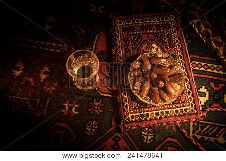Water And Dates. Iftar Is The Evening Meal. View Of Decoration Ramadan Kareem Holiday On Carpet. Fes