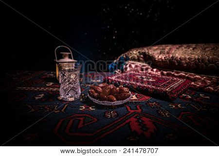 Water And Dates. Iftar Is The Evening Meal. View Of Decoration Ramadan Kareem Holiday On Carpet. Fes