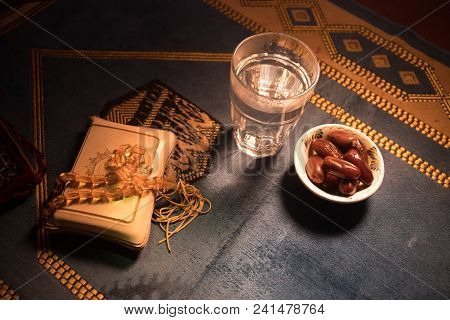 Water And Dates. Iftar Is The Evening Meal. View Of Decoration Ramadan Kareem Holiday On Carpet. Fes