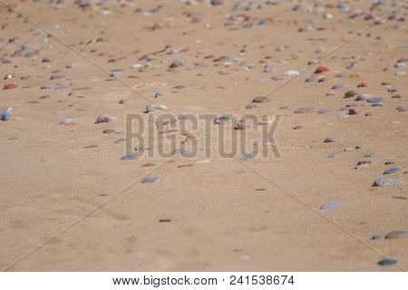 Beautiful Smooth Sea Stones In The Sands Of The Beach. Closeup Photo Of Stone Textures And Shapes.
