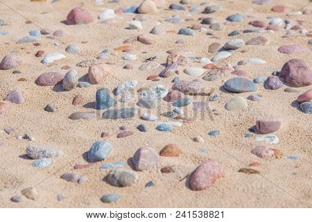 Beautiful Smooth Sea Stones In The Sands Of The Beach. Closeup Photo Of Stone Textures And Shapes.