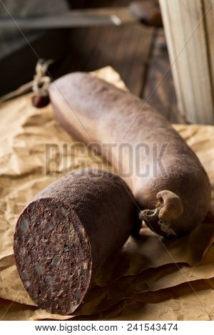 German Specialty Blood Sausage (blutwurst) On Wooden Table In Kitchen