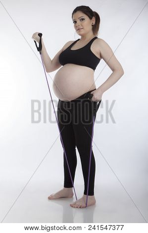 Pregnant Woman Doing Gymnastic Exercises On White Background