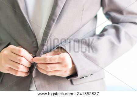 Businessman In Casual Fasten The Buttons Of The Grey Suit.
