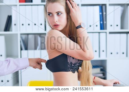 Man's Hand Pulls Bra Out Of The Beauitiful Secretary In Office Background. Flirt Or Harassment Conce