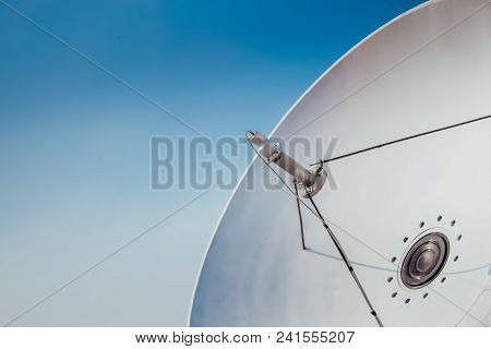 Satellite Dish And Tv Antennas On The House Roof With Blue Sky Background