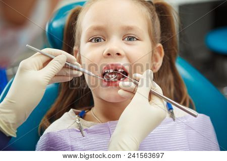 Child Lies In Comfortable Dentis Chair And Goes Through Procedure Without Fear While Female Doctor I