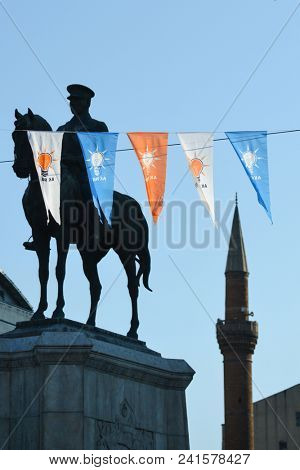 ANKARA, TURKEY - JANUARY 18, 2018: Flags of AK Party and Statue of Ataturk and a mosque minaret in Ulus, Ankara. The three symbols in Turkey symbolizes power struggle towards to Presidential elections