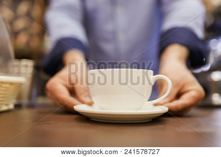 Image of barist man with cup of coffee
