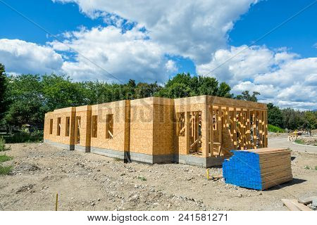 Wooden Frame Of New Building With Engineered Lumber Materials On Site Prepared For Construction. Tow
