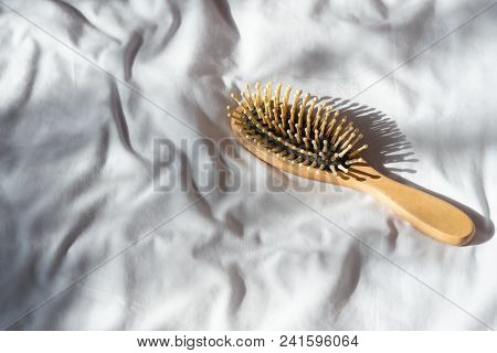 Hair Fall, Hair Loss Problem. Wooden Brown Comb With Hair Loss On White Bed Cover. Woman Healthy And