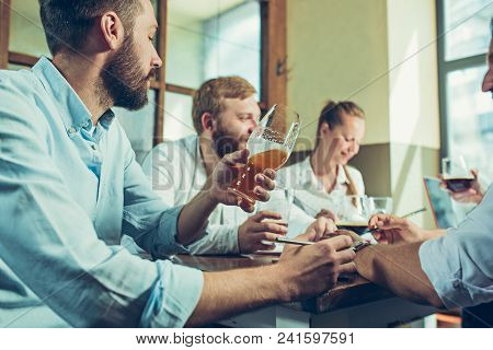 Young Cheerful People Smile And Gesture While Relaxing In Pub. Team Job. Photo Young And Mature Busi