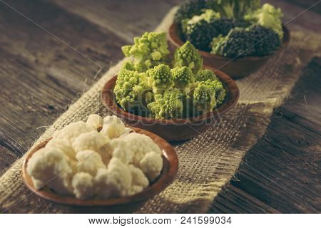 Fresh Pieces Of Romanesco Broccoli, Broccoli And Cauliflower In Small Rustic Wooden Bowls. Selective