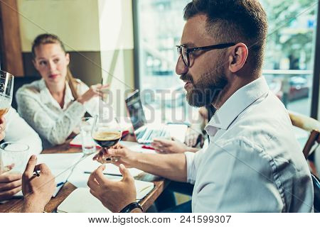 Young Cheerful People Smile And Gesture While Relaxing In Pub. Team Job. Photo Young And Mature Busi
