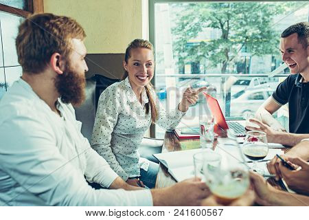 Young Cheerful People Smile And Gesture While Relaxing In Pub. Team Job. Photo Young And Mature Busi