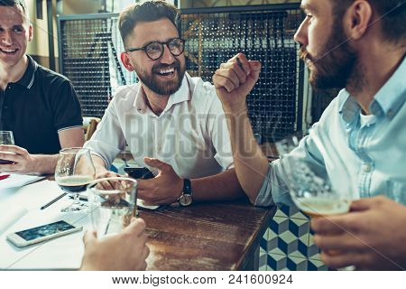 Young Cheerful People Smile And Gesture While Relaxing In Pub. Team Job. Photo Young And Mature Busi