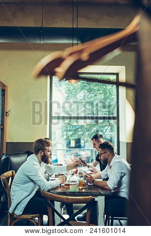 Young Cheerful People Smile And Gesture While Relaxing In Pub. Team Job. Photo Young And Mature Busi