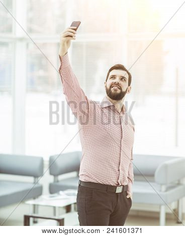 Successful Businessman Makes Selfie Standing Near The Window In The Spacious Office
