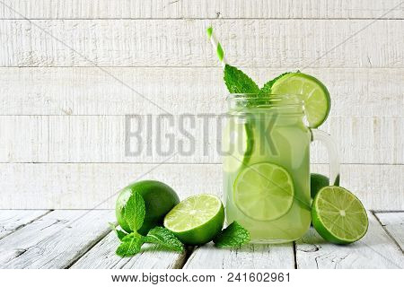 Homemade Limeade In A Mason Jar Glass. Side View On A Rustic White Wood Background.