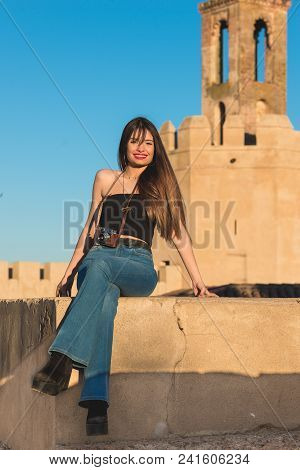 Beautiful Young Woman Traveler With  Camera Front Espantaperros Tower In Badajoz.