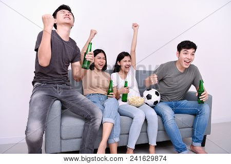 Concept Of Cheering. Asian Teenagers Watching Football On Television. People Are Cheering And Winnin