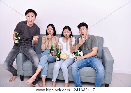 Concept Of Cheering. Asian Teenagers Watching Football On Television. People Are Cheering And Winnin