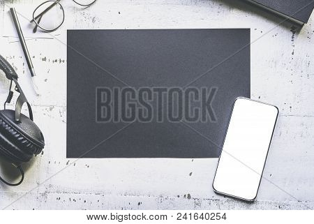 Mockup Of Blank Black Paper Sheet, Smartphone, Eye Glasses, Headphones On Natural White Authentic Wo