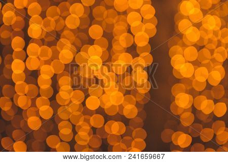 Many Blurred Small Electric Bulbs On A Wall. Yellow Blurred Lights. Wall Of Christmas Lights