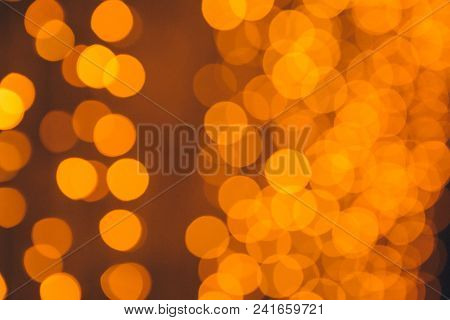 Many Blurred Small Electric Bulbs On A Wall. Yellow Blurred Lights. Wall Of Christmas Lights