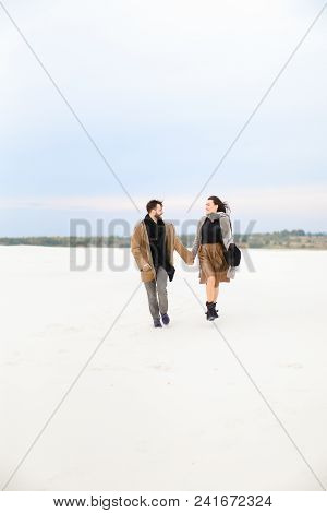 Female Person And Man Walking On Snow And Holding Hands, Winter Background. Concpt Of Seasonfl Photo