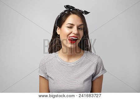 Portrait Of Seductive Coquettish Young Brunette Female Dressed Stylishly, Posing In Studio, Blinking