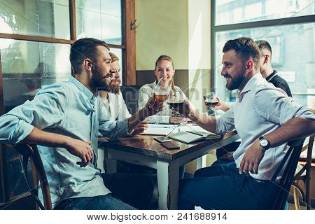 Young Cheerful People Smile And Gesture While Relaxing In Pub. Team Job. Photo Young And Mature Busi