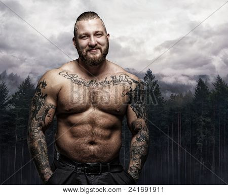 Positive Shirtless Tattooed Male Over Nature Background.