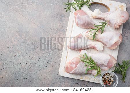 Raw Chicken Legs With Herbs And Spices On Cutting Board. Top View. Gray Background
