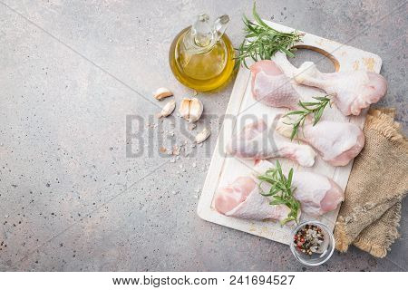 Raw Chicken Legs With Herbs And Spices On Cutting Board. Top View. Gray Background