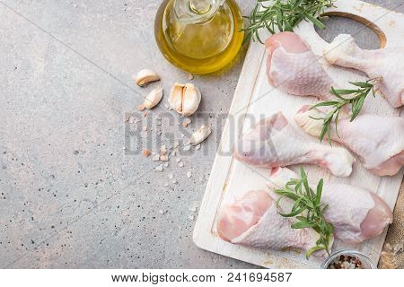 Raw Chicken Legs With Herbs And Spices On Cutting Board. Top View. Gray Background