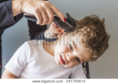 Close-up Of Man Hands Grooming Kid Boy Hair Iat Home