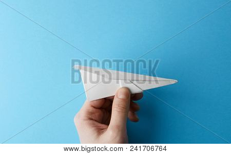 Paper Plane On Blue Background Holding In Male Hand. Travel And Tourism Concept. Horizontal