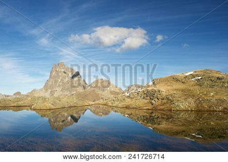 Midi Dossau Peak reflected in a lake. Ossau Valley, Pyrenees National Park, Pyrenees, France.