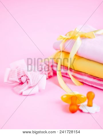 Newborn Stuff, Clothes And Pacifier For Baby Girl On Pink Background