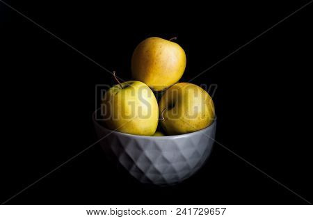 Bowl Of Yellow Apples. On Black Background. A