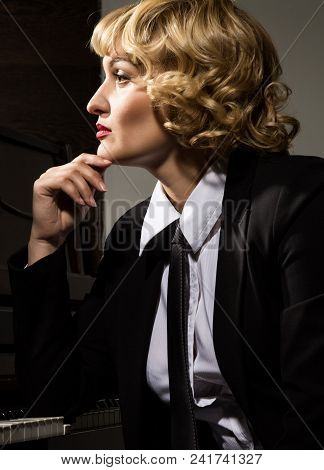 Beautiful Woman In A Business Suit Playing The Piano