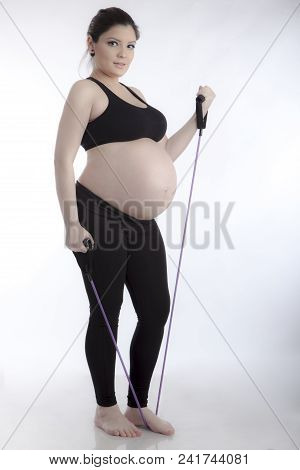 Pregnant Woman Doing Gymnastic Exercises On White Background