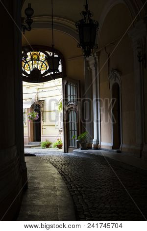 Ancient Narrow Passage To Backyard Of Residential Building. Old Empty Dark Corridor Through Old Anti
