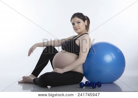 Pregnant Woman Is Doing Exercises With Gymnastic Ball On White Background